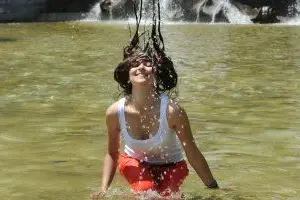 Una turista si rinfresca bagnandosi in una fontana