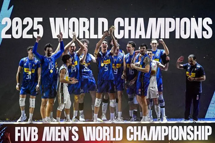 Gold medallists of team Italy celebrate on stage with the trophy after winning against Bulgaria during the 2025 Men's Volleyball World Championship at the Mall of Asia Arena in Pasay City, Metro Manila on September 28, 2025. (Photo by Ted ALJIBE / AFP)