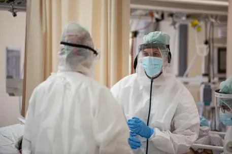 Operatori sanitari, che indossano tute protettive mediche e mascherine, al lavoro nella terapia intensiva dell'Ospedale Sant'Orsola di Bologna, 12 novembre 2020. Ieri in Italia Ã¨ stata superata la soglia dei 600.000 casi attualmente positivi, tra casi in isolamento domiciliare, ricoverati con sintomi e in terapia intensiva. Questo dato Ã¨ importante perchÃ©, un'epidemia si definisce 'fuori controllo' nel momento in cui i positivi superano l'1% della popolazione e ieri, oltre ad aver sperato il milione di casi da inizio pandemia, in Italia Ã¨ stato superata questa soglia di popolazione attualmente con infezione da Sars-Cov-2. Ansa/Max Cavallari