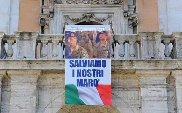 Uno dei tanti striscioni appesi nei comuni italiani per solidarietà ai due fucilieri