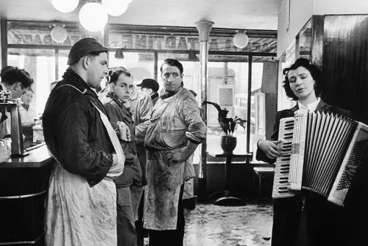 Ottanta scatti in bianco e nero nella Parigi degli anni '50 e '60. Nella foto "I macellai amanti della musica", Parigi, 1953. Courtesy Lu.C.C.A.