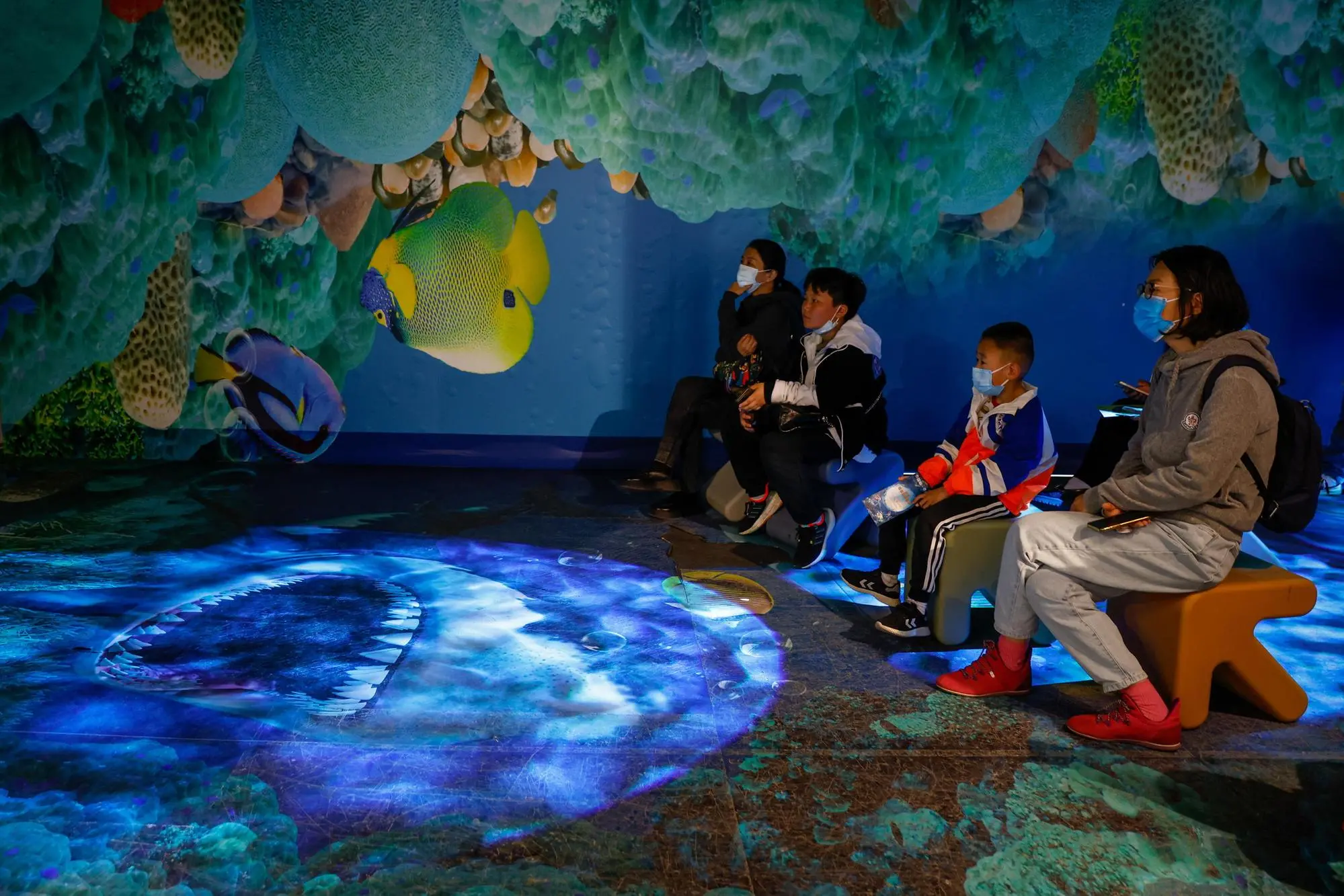 epa10584058 A family watches a video on marine life at the Geological Museum of China on the eve of Earth Day in Beijing, China, 21 April 2023. The museum has offered three days of free entry to mark Earth Day in China. Earth Day is celebrated worldwide annually on 22April with this year's theme as 'Invest in Our Planet' encouraging everyone to tackle current issues such as waste reduction, biodiversity loss and climate change. EPA/MARK R. CRISTINO