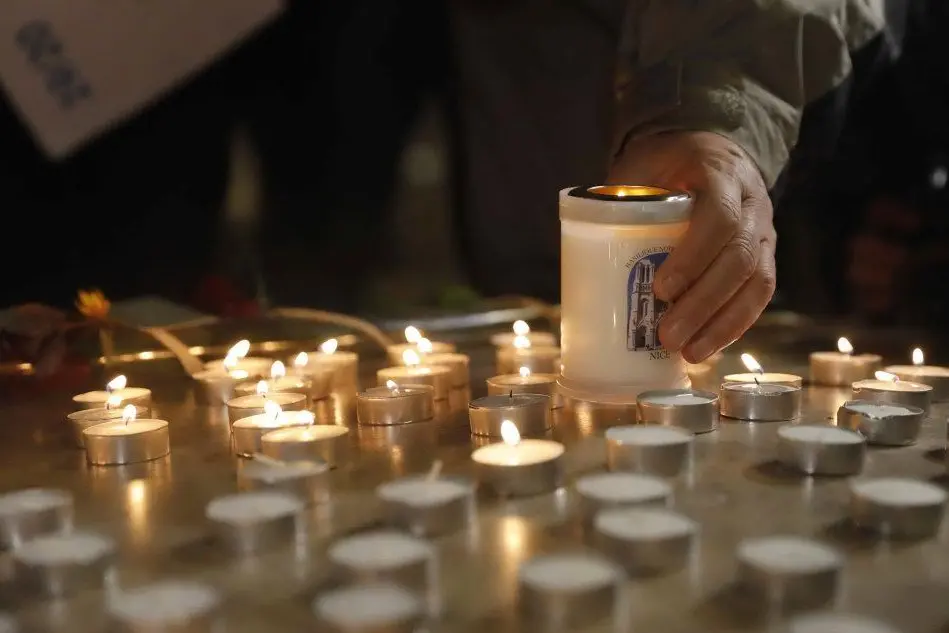 Candele all'ingresso della basilica di Nizza (foto Ansa/Epa)