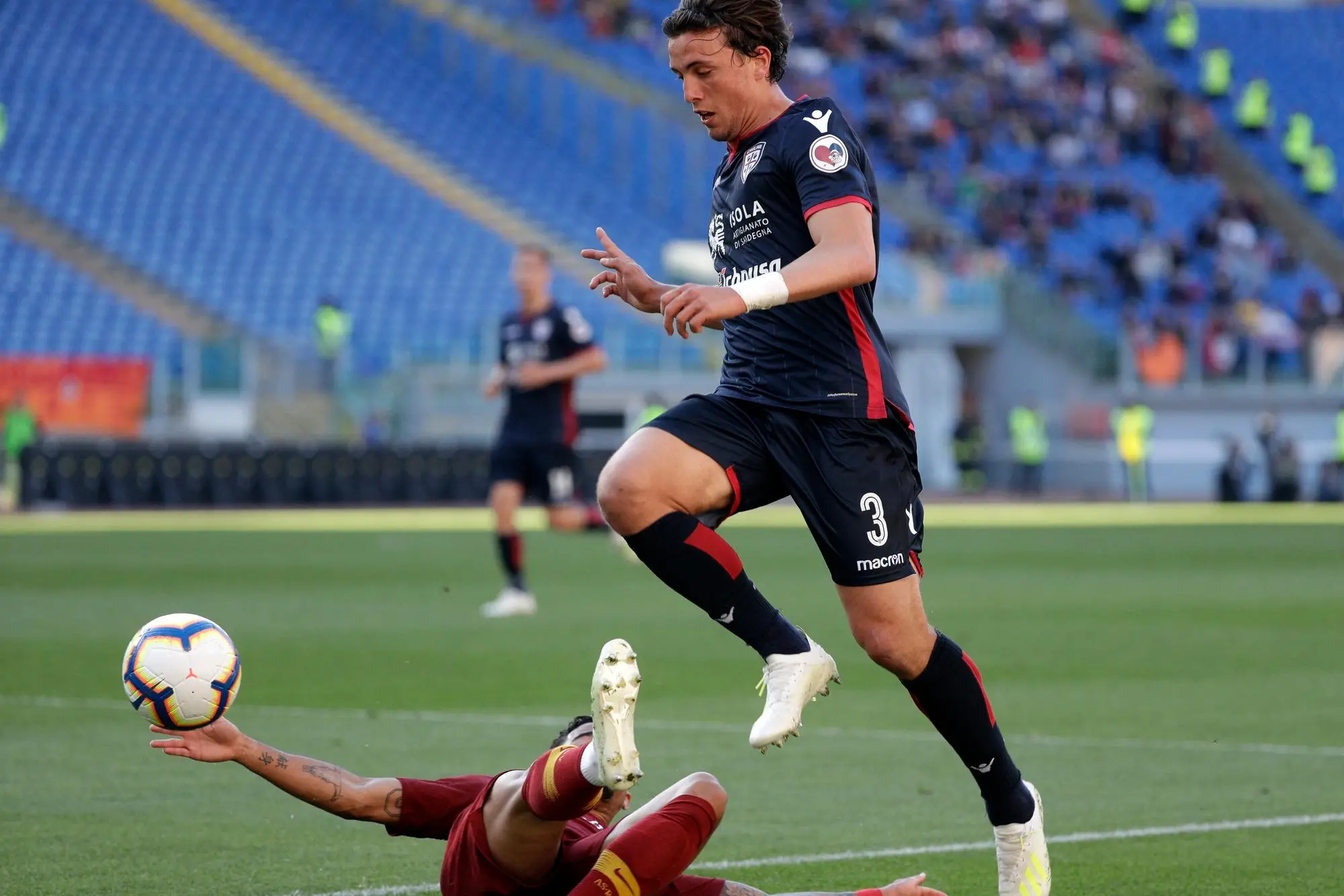 Roma's Justin Kluivert, on the ground, and Cagliari's Luca Pellegrini fight for the ball during a Serie A soccer match between Roma and Cagliari, at Rome's Olympic Stadium, Saturday, April 27, 2019. (AP Photo/Gregorio Borgia)